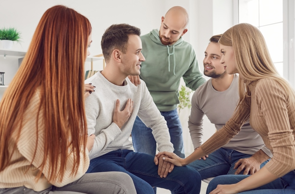 Group smiling during an Alcoholics Anonymous session